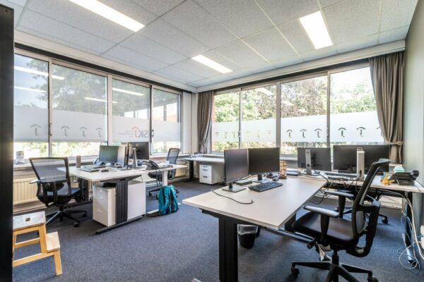 Modern kantoor met meerdere werkplekken en grote ramen aan de Jan van Eycklaan.
